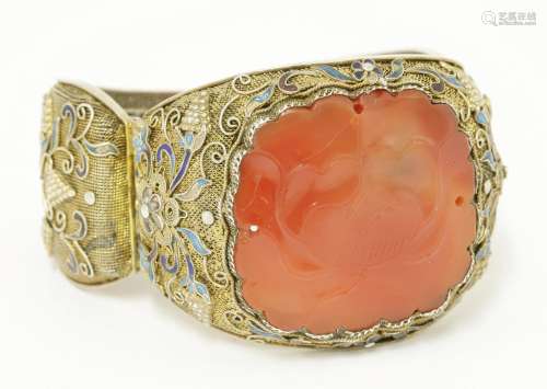 A Chinese silver gilt hinged bangle, 1930s, inset with an agate plaque carved with peony, the mesh ...
