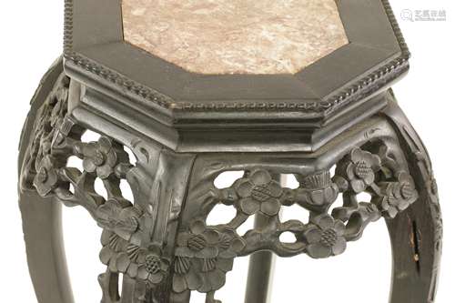 A Chinese black wood stand, c.1880, the octagonal top inset with rouge marble, supported by ...