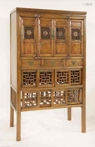 A Chinese cupboard, early 20th century, with four pierced door panels, each with a character ...