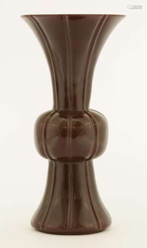 A Chinese monochrome Peking glass vase, of gu form, the oxblood body with vertical fluting, 20cm  ...