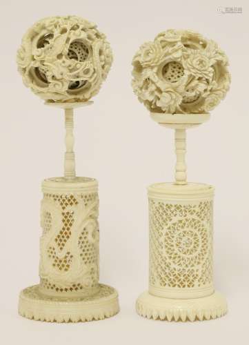 Two Canton ivory balls and stands, late 19th century, one ball exterior carved with dragons amongst ...