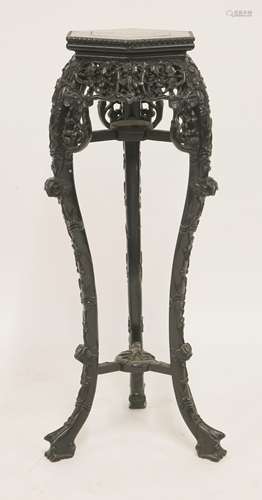 A Chinese hardwood stand, of hexagonal top inset with rouge marble, supported by pierced and carved ...