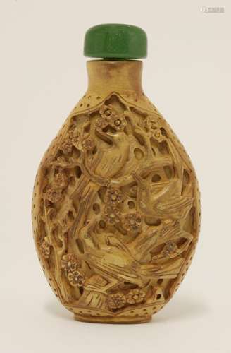 A boxwood snuff bottle, 20th century, carved with magpies on a blossoming prunus tree