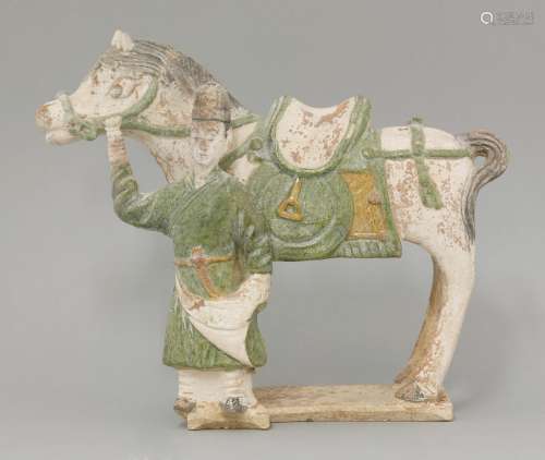 A tomb figure,  Ming dynasty (1368-1644), of a pony, its reins held by an attendant, details glazed ...