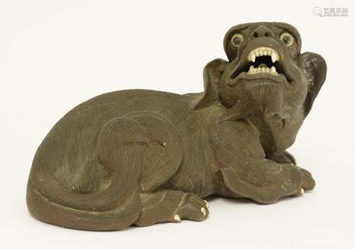 A Chinese stoneware model, 19th century, maybe Yixing, of a recumbent Buddhist lion with his head ...