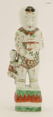 A Chinese porcelain famille verte figure, 17th century, of a boy holding a vase with another boy ...