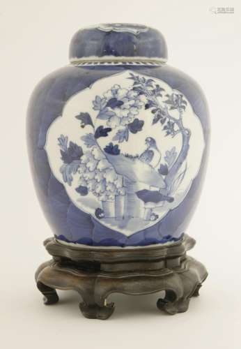 A Chinese blue and white ginger jar and cover, late Qing dynasty, painted with a lady playing with ...