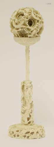 A Canton ivory ball and stand, late 19th century, the ball exterior carved with dragons amongst ...