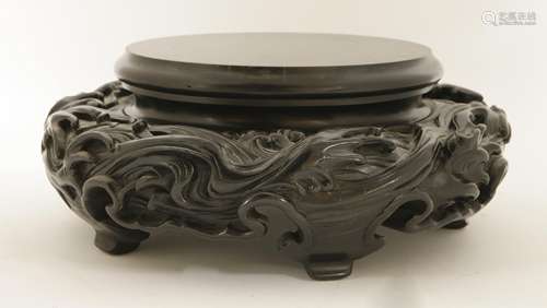 A Japanese wood stand, early 20th century, of circular form, carved with spuming waves, 37.5cm