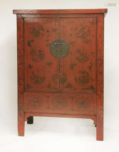 A Chinese red lacquered wedding cabinet, late 19th century, the two hinged doors, with a large ...