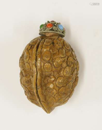 A walnut snuff bottle, of a thousand faces, with metal stopper, 5cm