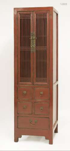 A Chinese red lacquered cabinet, late 19th century, with spindle upper doors above five drawers, ...