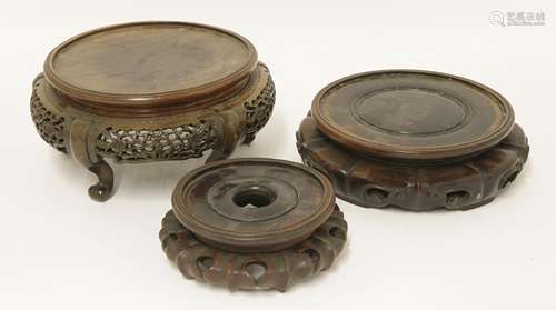 Three Chinese wood stands, one with pierced apron on shaped legs, largest 24cm diameter (3)