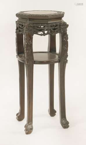 A Chinese rosewood vase stand, c.1900, of hexagonal form, pierced and carved with fruiting vine, ...