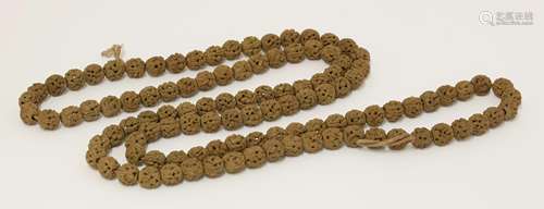 A string of Chinese nut kernels beads, early 20th century, each pierced and carved with figures, ...