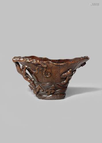 A CHINESE RHINOCEROS HORN 'NINE DRAGON' LIBATION CUP 17TH CENTURY Carved in the form of a large