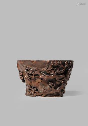 A CHINESE BAMBOO 'PRUNUS' LIBATION CUP EARLY QING DYNASTY With a tapered body carved with gnarled