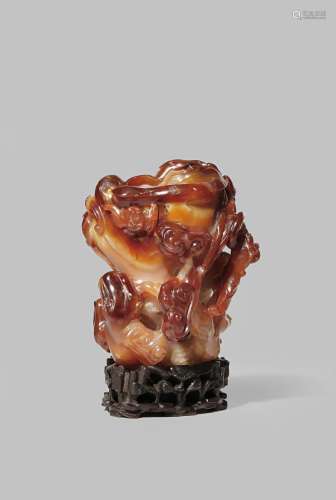 A CHINESE CARNELIAN-AGATE VASE 18TH/19TH CENTURY Carved as an old tree trunk overgrown with