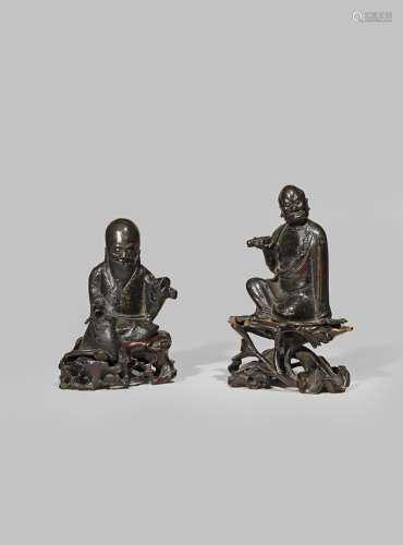 A SMALL CHINESE BRONZE FIGURE OF A LUOHAN LATE MING DYNASTY Seated, wearing flowing robes and