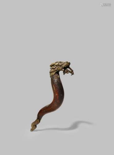 A TIBETAN BRONZE MOUNTED WOOD HANDLE 17TH/18TH CENTURY Formed as a dragon, with an S-shaped body,