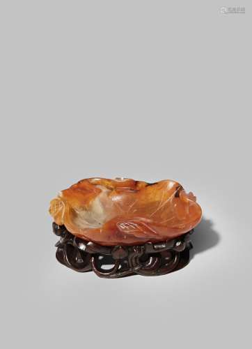 A CHINESE CARNELIAN-AGATE BRUSH WASHER 19TH CENTURY Carved as a curved lotus leaf with seed pods and