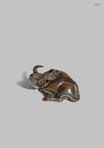 A CHINESE BRONZE BUFFALO WATER DROPPER LATE MING DYNASTY Recumbent, with his head turned to