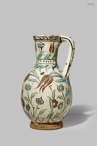 AN IZNIK POTTERY EWER EARLY 17TH CENTURY The body freely painted with black, sealing-wax red,