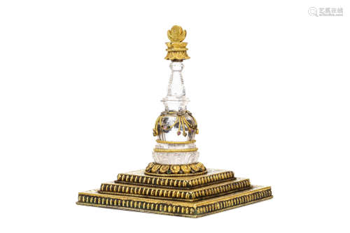 A ROCK CRYSTAL AND GILT BRONZE STUPA. 19th Century. The gilt bronze stepped base of square