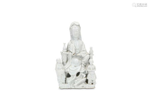 A CHINESE DEHUA FIGURE OF GUANYIN. Qing Dynasty, circa 1700. Seated on a rocky thrown, a young boy