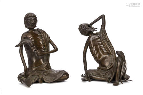 TWO BRONZE EMACIATED MONKS. 19th Century. Each seated in trailing robes, a haunted expression on the