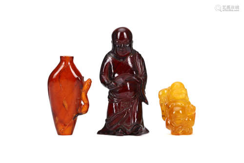 THREE CHINESE AMBER CARVINGS. 19th / 20th Century. Comprising a snuff bottle with a chi dragon