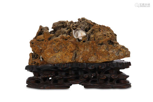 A CHINESE SCHOLAR'S ROCK. Qing Dynasty. The uneven openwork stone with shell inclusions, the wood