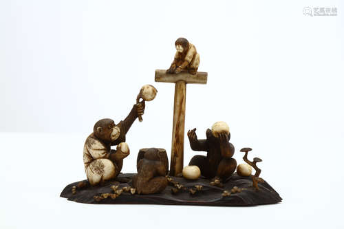 AN IVORY AND BONE OKIMONO OF MONKEYS. Meiji period. An adult monkey in kimono seated, proffering a