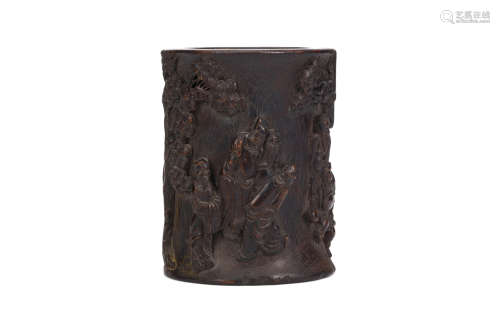 A CHINESE WOOD BRUSHPOT. Carved around the body with figures in a landscape beneath pines engaged in