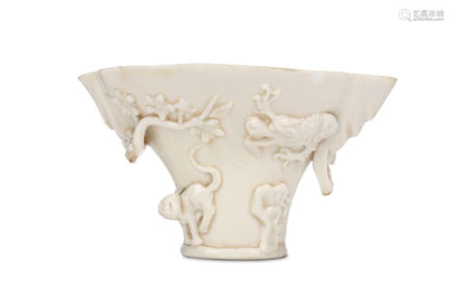 A CHINESE DEHUA LIBATION CUP. Qing Dynasty. Moulded in high relief to depict a dragon tiger and