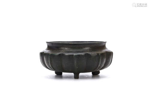 A TRIPOD BRONZE CENSER. Ming Dynasty. The body modelled with vertical stylised lappets rising to