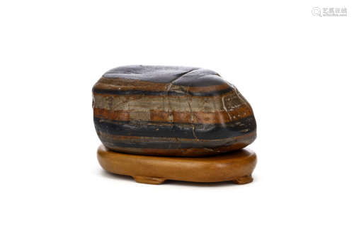 A MINIATURE CHINESE SCHOLAR’S ROCK. The stone stratified into different coloured layers, wood stand,