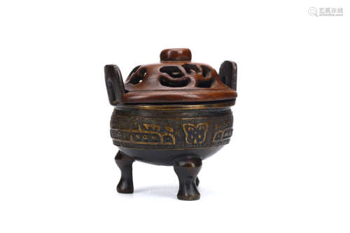 A CHINESE BRONZE CENSER WITH WOOD COVER. 17th / 18th Century. Supported on tripod feet the rim set