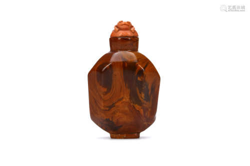 A CHINESE FACETED AMBER SNUFF BOTTLE. Qing Dynasty. With faceted sides, coral stopper incised as a