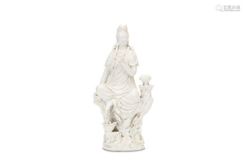 A CHINESE BLANC DE CHINE GUANYIN. Qing Dynasty. Seated on a rocky base with the left arm raised,