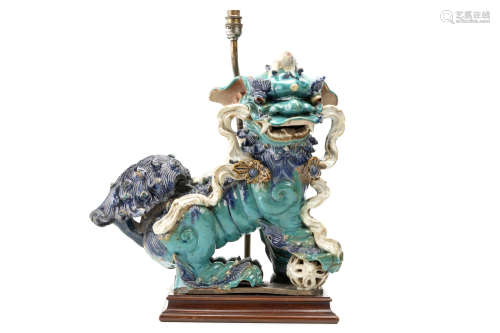A CHINESE TURQUOISE GLAZED BUDDHIST LION DOG ROOF TILE. Ming Dynasty. Seated with the right front