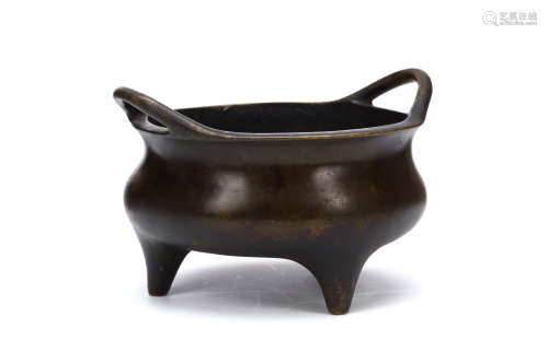 A CHINESE TRIPOD LOOP HANDLE BRONZE CENSER. Qing Dynasty. The blombé-form body supported on three