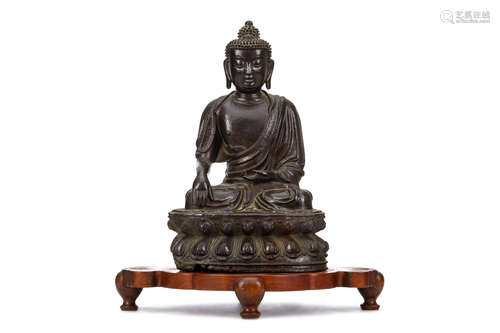 A CHINESE BRONZE SEATED FIGURE OF BUDDHA. Ming Dynasty. Seated in vajraparyankasana on a double-