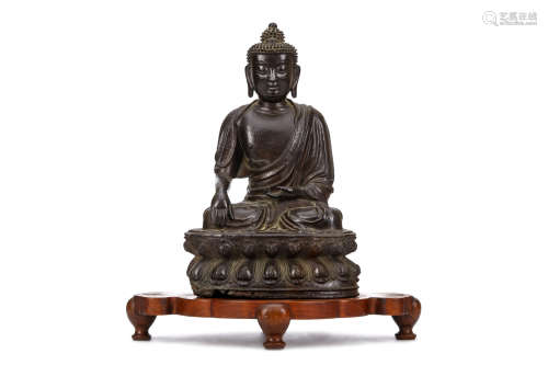A CHINESE BRONZE SEATED FIGURE OF BUDDHA. Ming Dynasty. Seated in vajraparyankasana on a double-