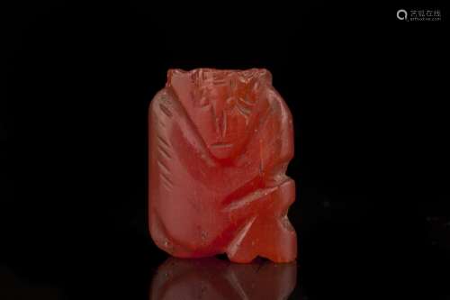 An intriguing Chinese red glass figural bead,