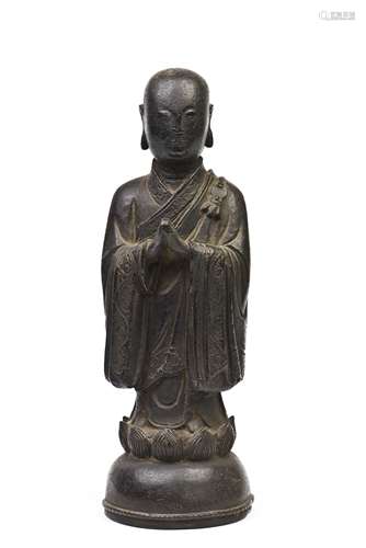 A BRONZE FIGURE OF A STANDING MONK