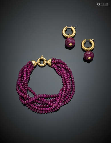 Ovaloid and faceted ruby bead jewellery set composed of a six strand bracelet with yellow gold snap-hook as are the earrings each with a removable ovaloid faceted ruby of mm 14 circa, in all g 54.70. Bracelet length cm 20 circa