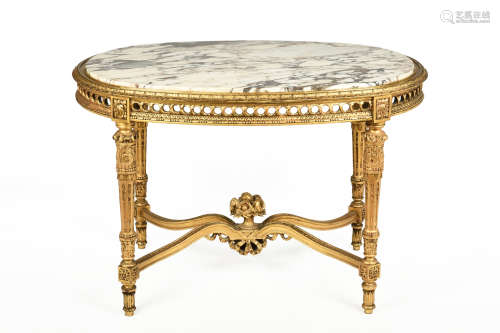 LOUIS XVI GILTWOOD CARVED OVAL SHAPED MARBLE TOP SALON TABLE WITH FLORAL FILLED URN MOUNTED STRETCHER