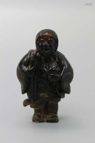 Japanese carved horn netsuke of a figurine.