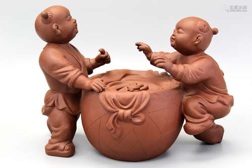 Chinese Yixing pottery figure of two boys playing drum.